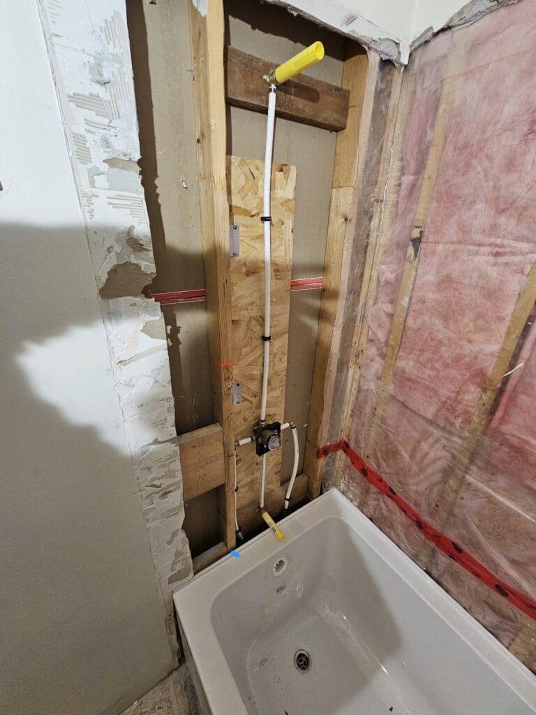 Supply lines and tub valve roughed in behind the new bathtub