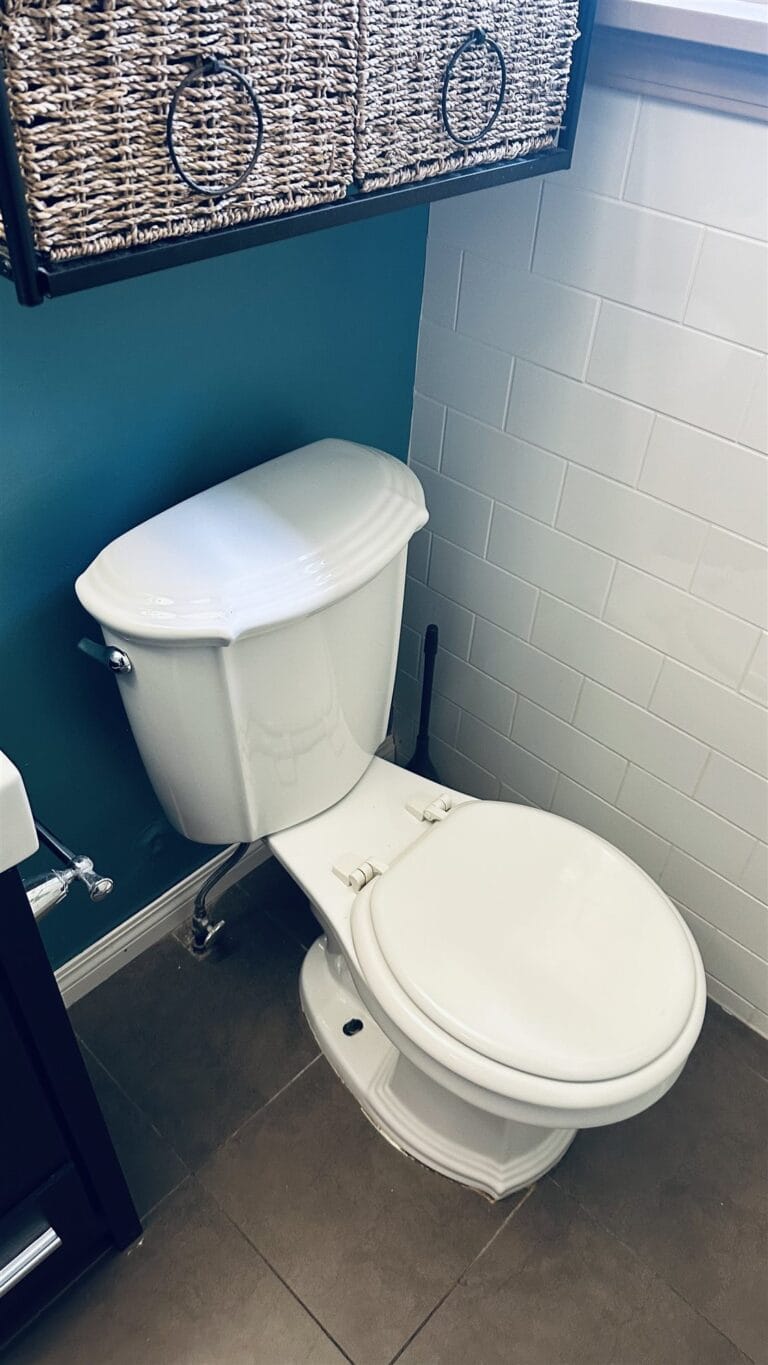 Close view of the two-piece toilet and chrome supply line