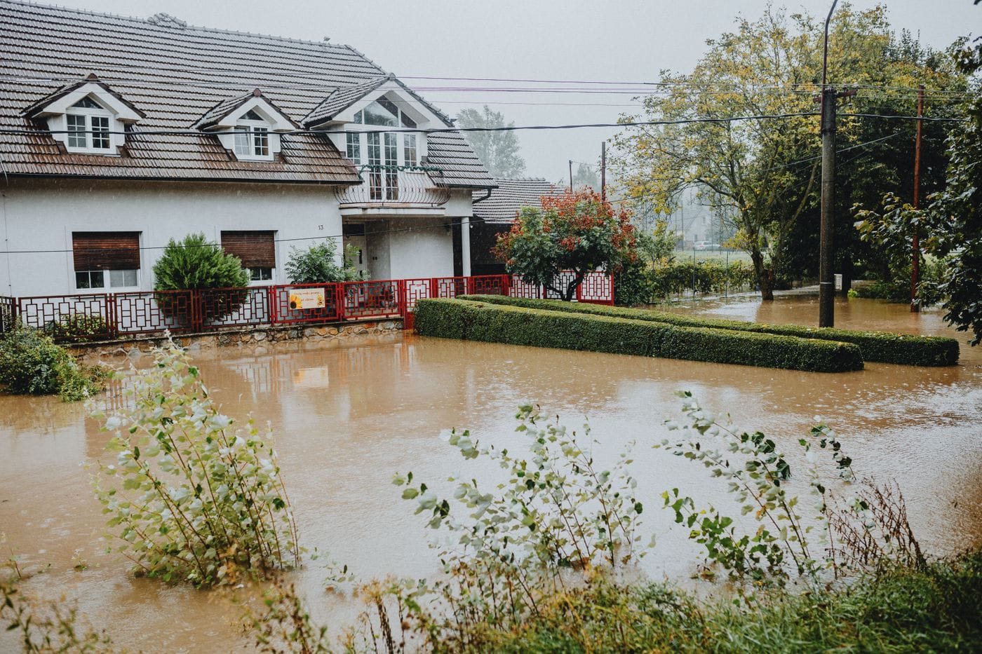 A suburban house surrounded by standing water after heavy rain