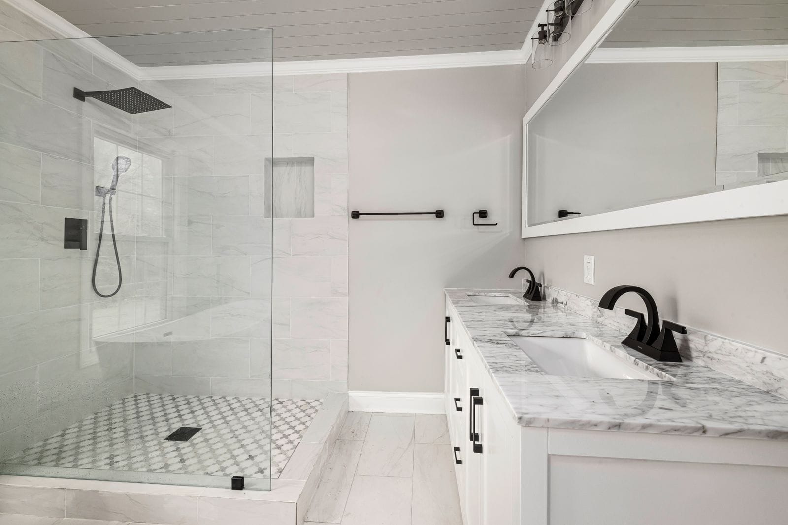 Glass-enclosed shower in a marble bathroom