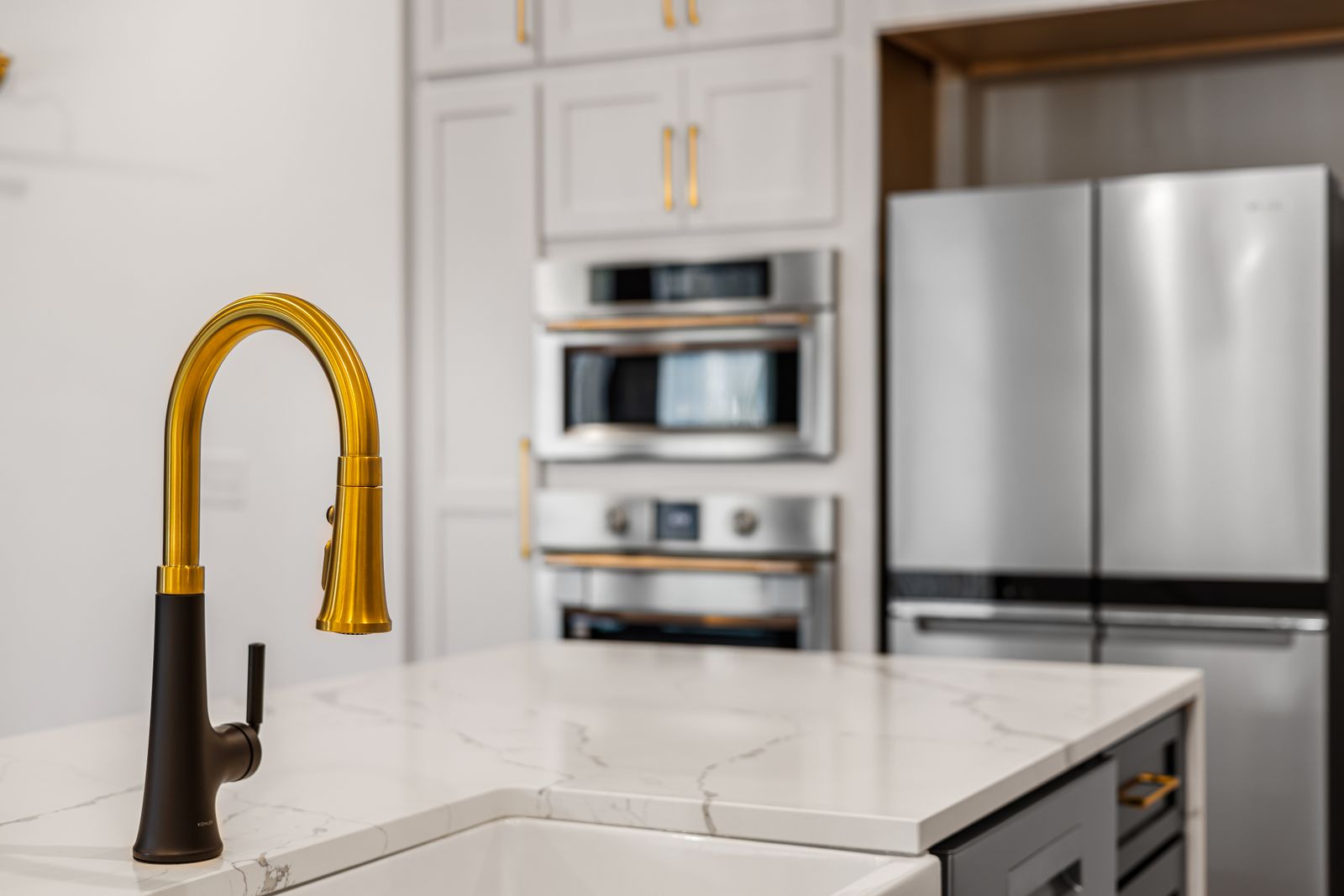 Kitchen island with a brass pull-down tap and a quartz countertop