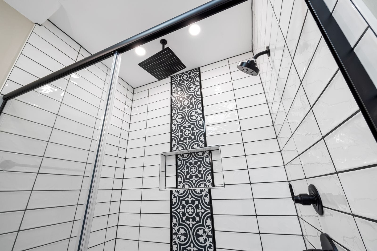 Tiled shower with a ceiling rain head and hand shower