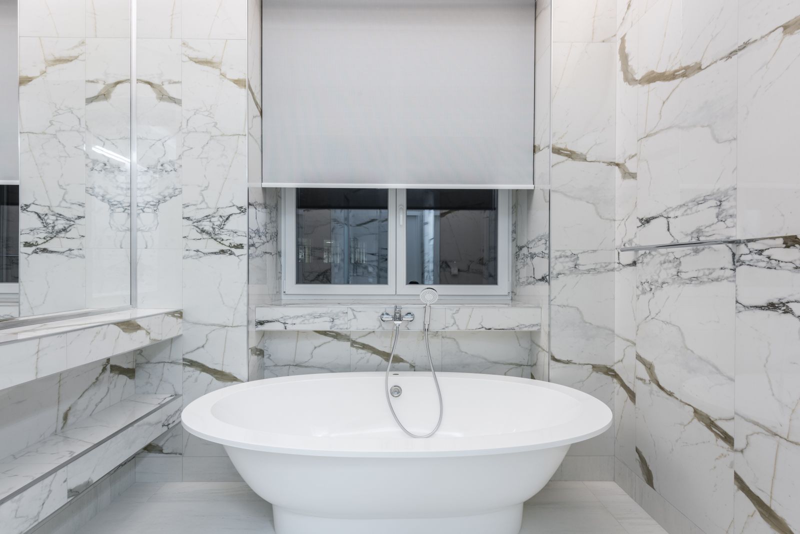 Marble bathroom with a freestanding tub and a floor-mounted tub filler